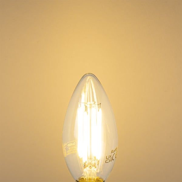 Eingeschaltete LED-Filament-Kerze mit klarem Glas und warmweißem Licht.