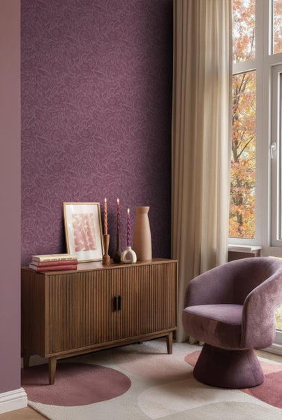 Wohnzimmer mit gemusterter Tapete, Holzkommode und Sessel