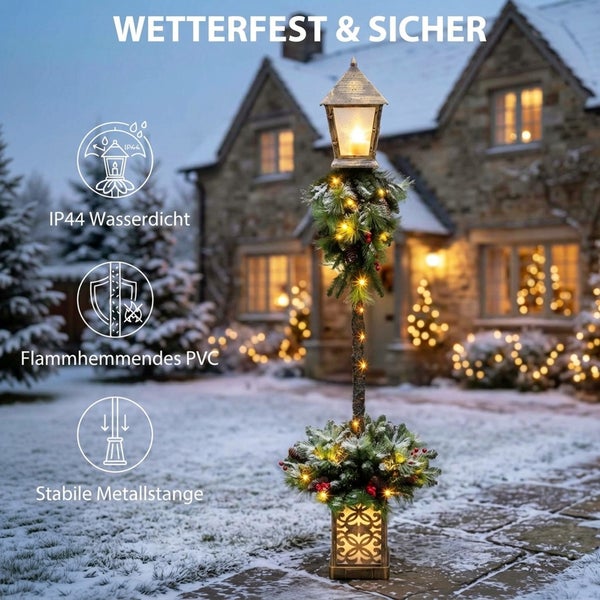 Weihnachtliche Laterne mit LED Beleuchtung und Tannenzweigen auf stabiler Metallstange fuer den Aussenbereich mit Schutzart IP44.