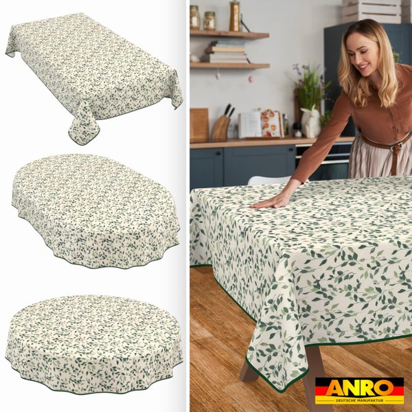 Abwaschbare Tischdecke mit Blättermuster in rechteckiger, ovaler und runder Form auf einem Holztisch in einer hellen Küche. ANRO Logo.