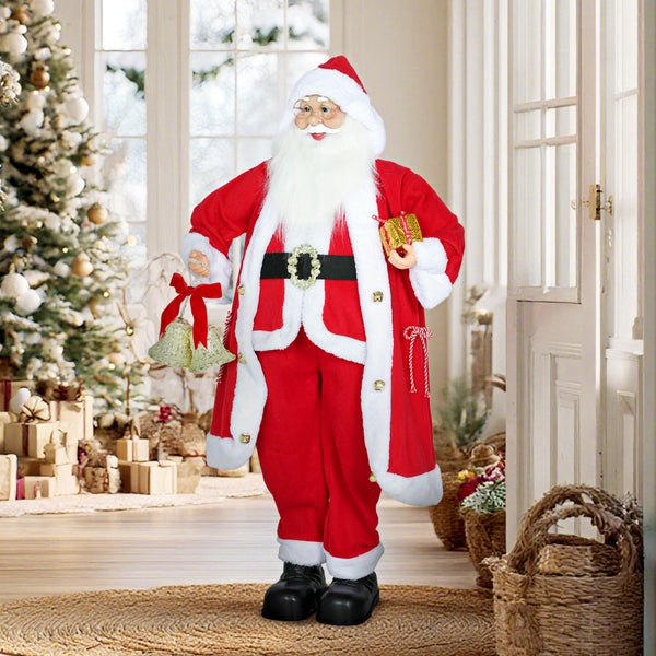 Stehende Weihnachtsmann-Figur mit Glocken und Geschenk in einem hellen, festlich dekorierten Raum mit Weihnachtsbaum.
