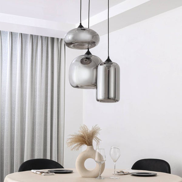 Moderne Pendelleuchte mit drei Schirmen aus verspiegeltem Glas in verschiedenen Formen über einem gedeckten Esstisch im hellen Esszimmer.