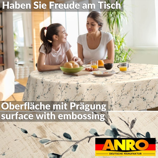 Rundes Tischtuch mit geprägter Oberfläche und floralem Muster auf einem gedeckten Tisch mit Frau und Mädchen in einem hellen Raum, ANRO Logo.