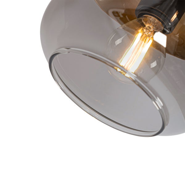 Nahaufnahme einer Pendelleuchte mit rundem, grauem Glasschirm und leuchtendem Filament-Leuchtmittel.