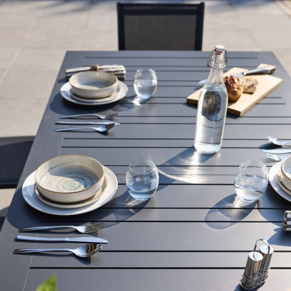 Türkisfarbenes Gartenmöbel-Set aus Metall mit einem quadratischen Tisch und acht stapelbaren Gartenstühlen mit Armlehnen und Latten-Design.