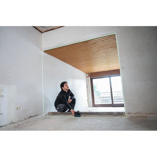 Mann benutzt Laser-Wasserwaage in einem Raum mit Holzdecke