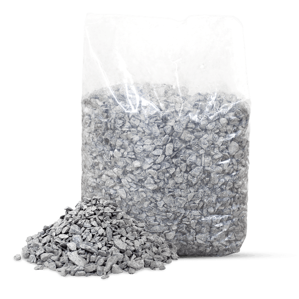 Grauer Splitt in einem transparenten Kunststoffsack mit einem kleinen Steinhaufen davor.