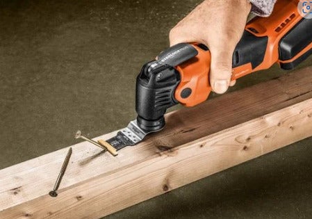Ein Akku Multitool beim Schneiden einer Schraube in einem Holzbalken.