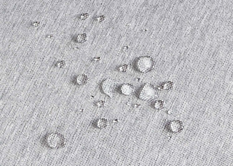 Nahaufnahme eines wasserabweisenden Stoffes mit Wassertropfen