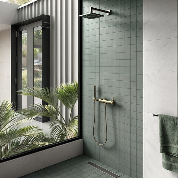 Moderne Dusche mit quadratischen Fliesen, Regendusche und Handbrause sowie bodengleichem Ablauf vor einer großen Fensterfront mit Pflanzen.