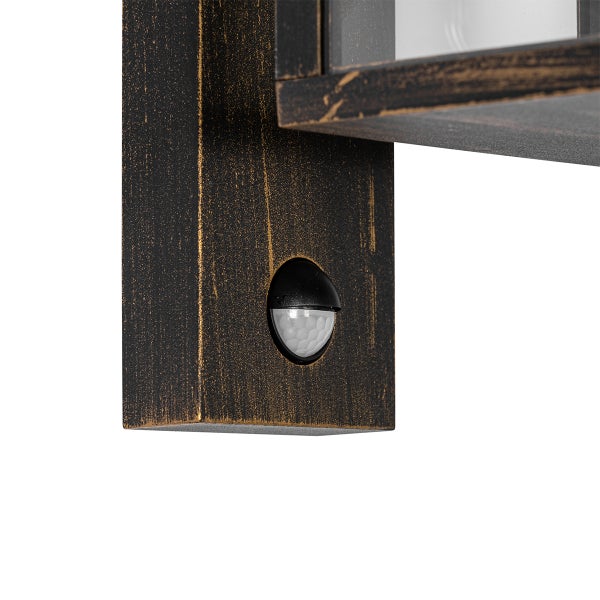 Detailansicht einer Außenwandleuchte mit Bewegungsmelder und Metalloberfläche in Antik-Optik.