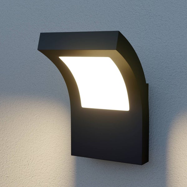 Moderne Außenwandleuchte in Schwarz mit warmweißem LED-Licht an einer strukturierten Wand.