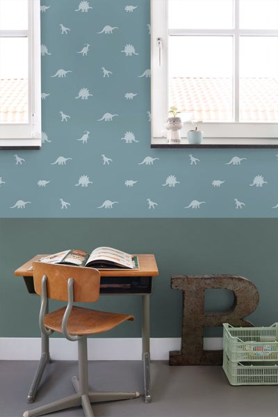 Kinderzimmer mit Dinosaurier-Tapete, Schreibtisch und Stuhl.