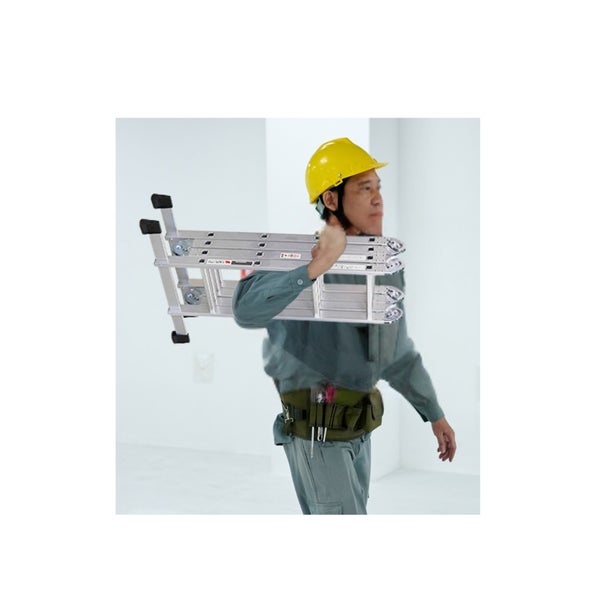Eine Person mit Schutzhelm und Werkzeuggürtel trägt eine zusammengeklappte Multifunktionsleiter aus Aluminium auf der Schulter.