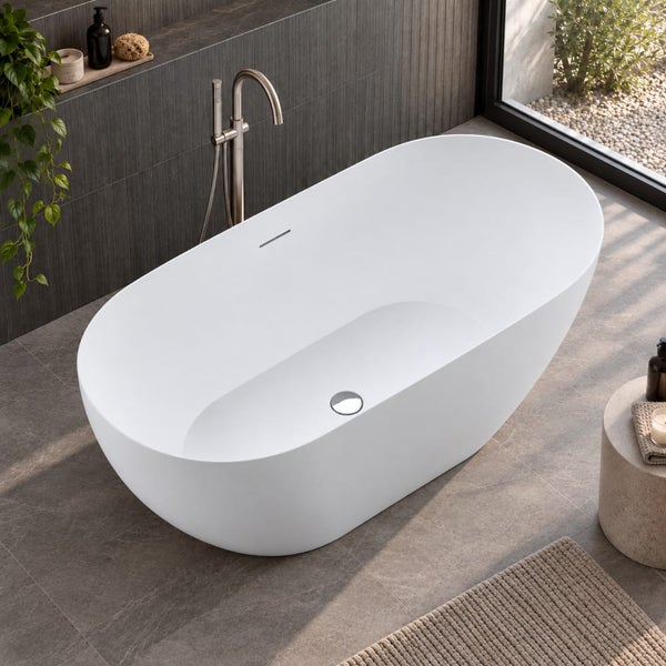 Freistehende ovale Badewanne in einem modernen Badezimmer mit bodentiefem Fenster, dunklen Wandfliesen und Armatur.