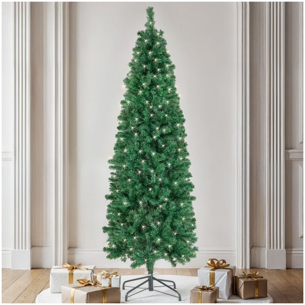 Künstlicher Weihnachtsbaum mit integrierter Lichterkette in einem Wohnraum mit Weihnachtsgeschenken.