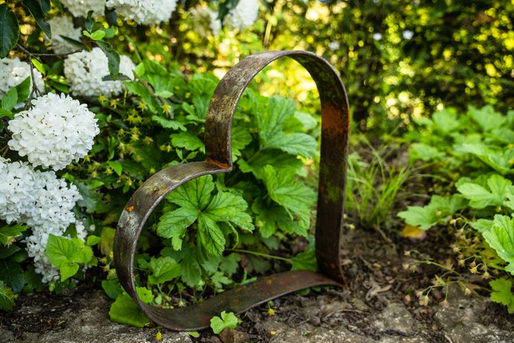 Dekorierter Esstisch im Freien mit Kerzen, Blumen und rustikalem Metallschmuck