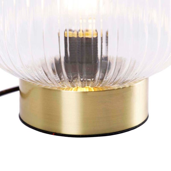 Nahaufnahme einer Tischleuchte mit geripptem Glasschirm und Metallsockel