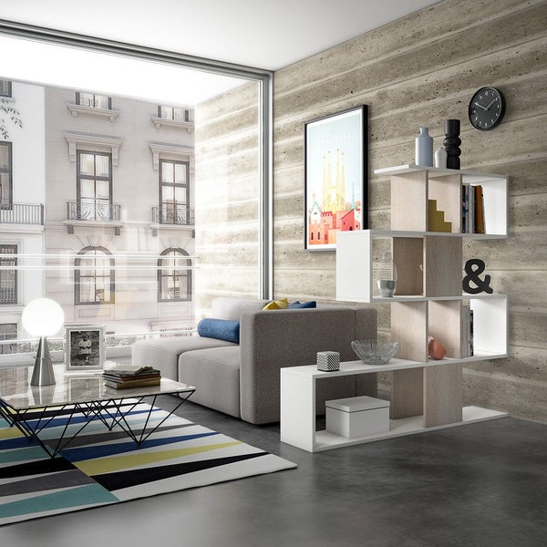 Wohnzimmer mit grauer Couch, Bücherregal und dekorativem Teppich