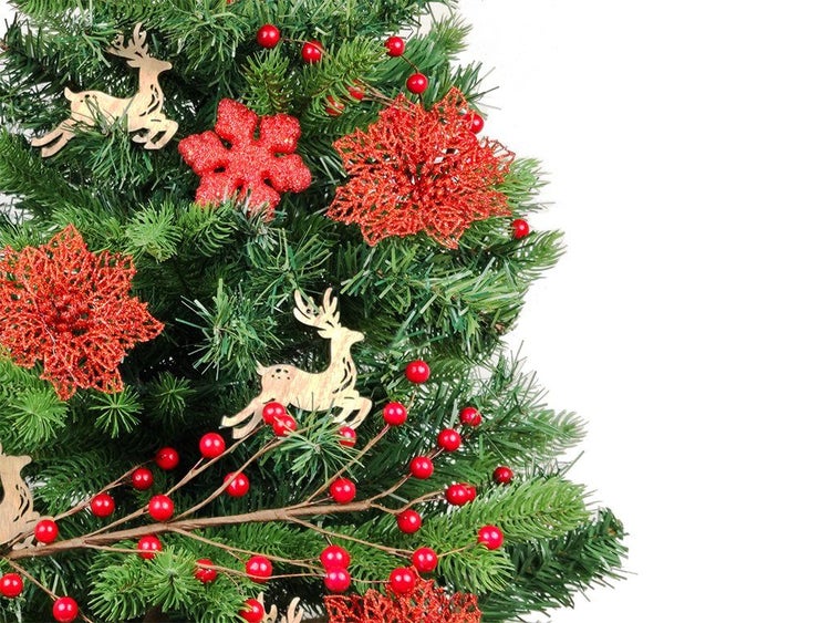 Weihnachtsbaum mit Dekoration aus Rentier Figuren aus Holz und roten glitzernden Weihnachtssternen und Beeren
