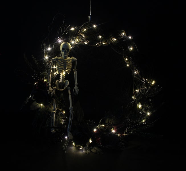 Dekorativer Halloween-Kranz mit Skelett und Lichtern für eine gruselige Atmosphäre