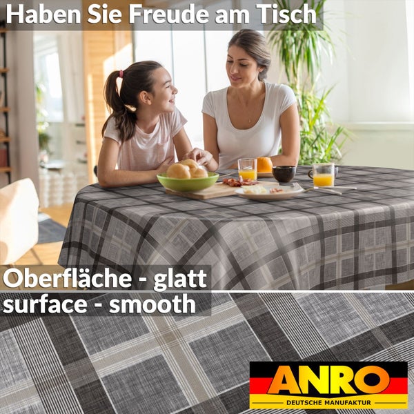 Karierte Tischdecke mit glatter Oberfläche auf einem gedeckten Esstisch in einer hellen Küche, ANRO Deutsche Manufaktur Logo.