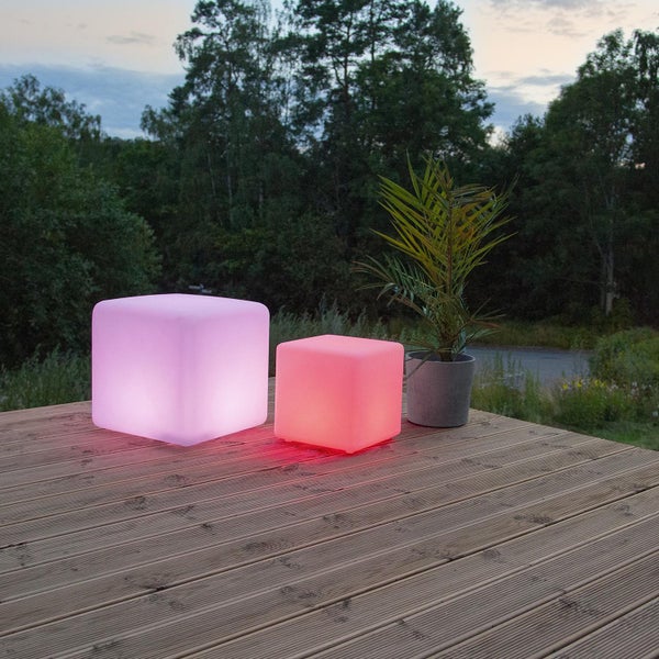 Beleuchtete Würfel und Topfpflanze auf einer Holzterrasse