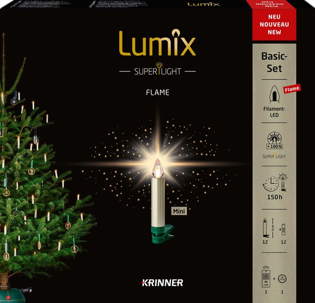 Lumix Christbaumkerzen Basic-Set mit Flammeneffekt auf einer Produktverpackung neben einem dekorierten Weihnachtsbaum