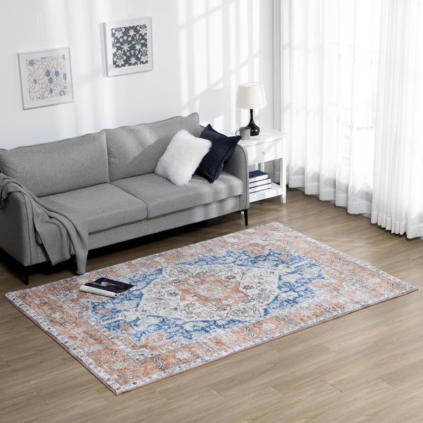 Wohnzimmer mit gemustertem Teppich, Sofa und Beistelltisch