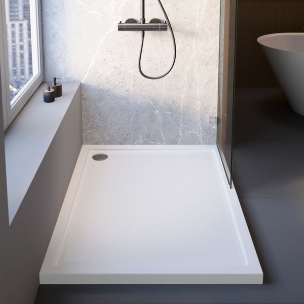 Moderne Duschecke mit einer flachen, rechteckigen weißen Duschwanne, einer gläsernen Duschwand und einer marmorierten Wand mit Armatur.