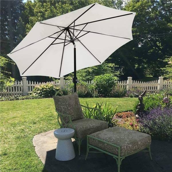 Gartenmöbel-Szene mit Sonnenschirm, Stuhl, Hocker und Beistelltisch im Garten