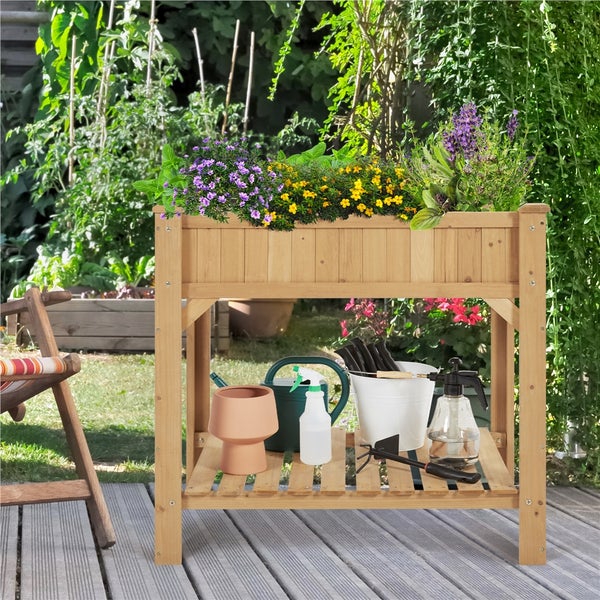 Hochbeet aus Holz mit Blumen und Gartengeräten