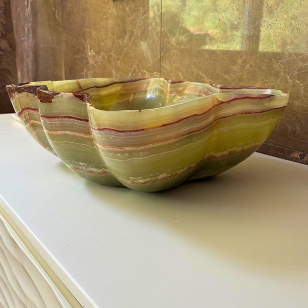 Aufsatzwaschbecken aus Naturstein mit organischer Form und horizontaler Maserung.