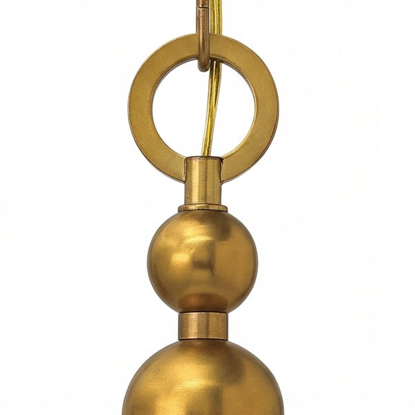 Detail einer goldenen Pendelleuchte mit Ringaufhängung