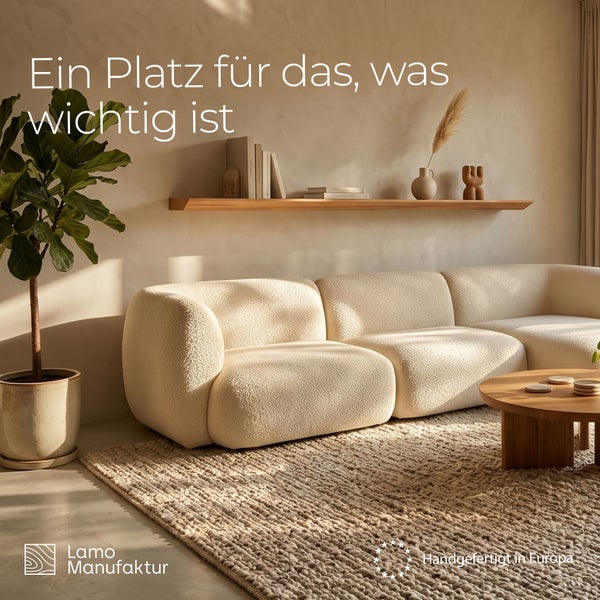 Modernes Wohnzimmer mit Bouclé-Sofa, Holztisch, Wandregal und Teppich. Lamo Manufaktur Logo. Handgefertigt in Europa.