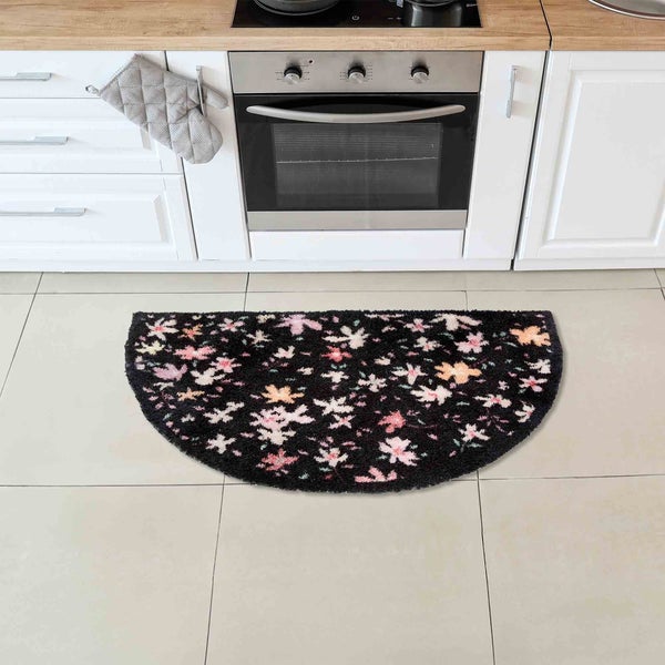 Halbrunde, schwarze Küchenmatte mit floralem Muster vor Küchenzeile
