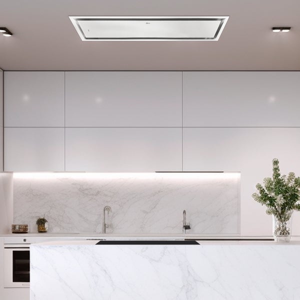 Moderne, hell gestaltete Küche mit weißer Deckenhaube, weißen Schränken und Arbeitsflächen in Marmoroptik.