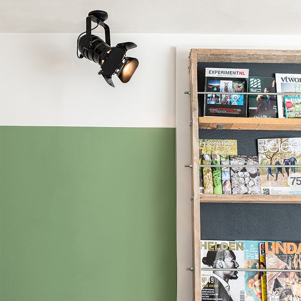Schwarzer Deckenstrahler neben einem Zeitschriftenregal im Innenraum.