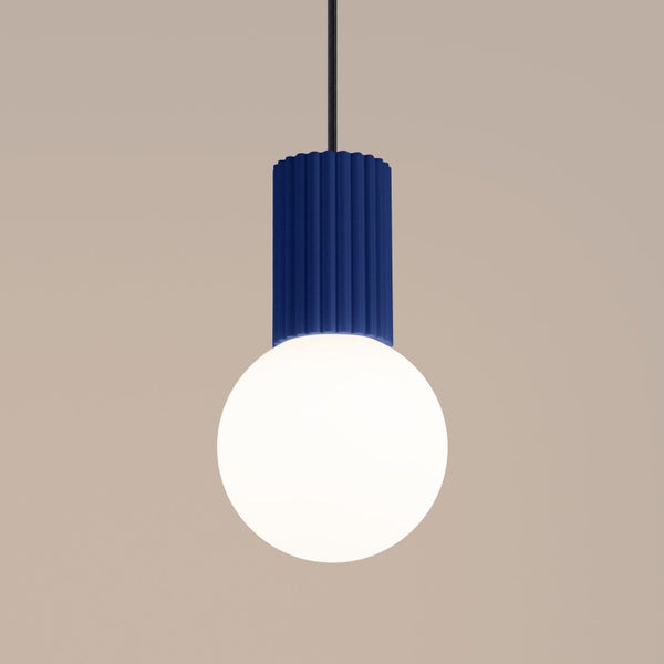 Blaue Pendelleuchte mit geriffeltem Sockel und großer weißer Kugelbirne an schwarzem Kabel.