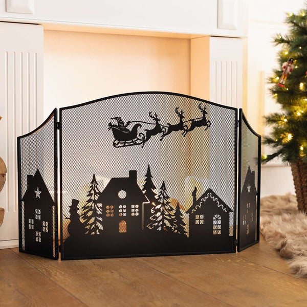 Schwarzer Funkenschutz mit Weihnachtsmotiv vor einem Kamin
