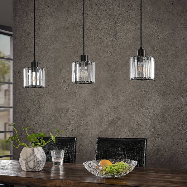 Drei Glaspendelleuchten über einem Esstisch mit Dekoration.