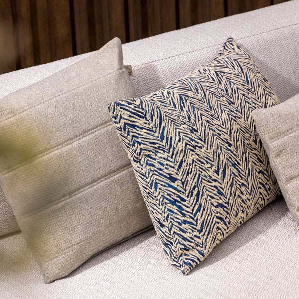 Dekorative Kissen auf einem Sofa, mit unterschiedlichen Texturen und Mustern.