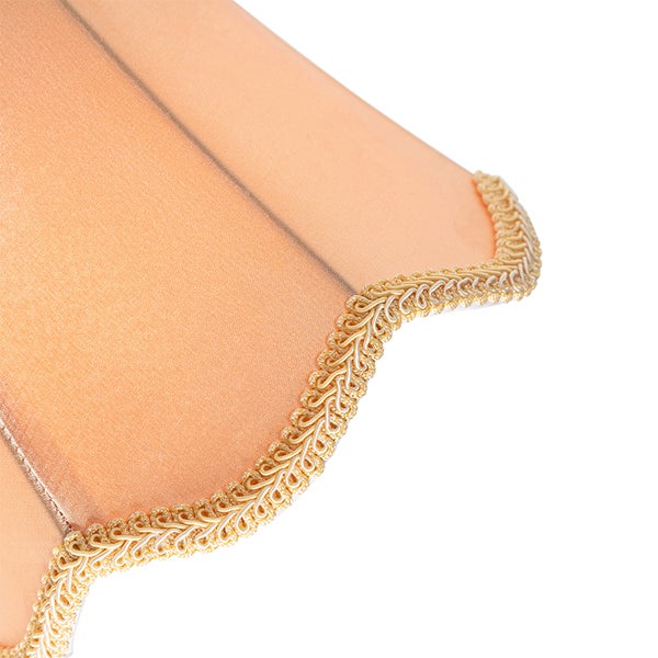 Detailaufnahme eines Lampenschirms aus Stoff mit dekorativer Flechtborte am wellenförmigen unteren Rand.