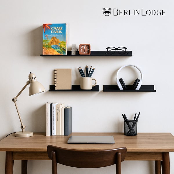 Schwarze Bilderleisten aus Metall von Berlin Lodge über einem organisierten Holzschreibtisch mit Laptop und Lampe. Berlin Lodge Logo.