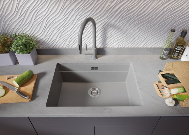 Küchenspüle aus Granit mit Armatur, Schneidebrett und Lebensmitteln