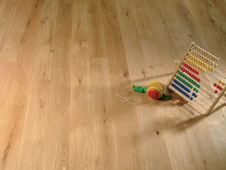 Heller Holzboden aus Eiche mit natürlicher Maserung, auf dem ein hölzerner Rechenschieber und ein buntes Spielzeug liegen.