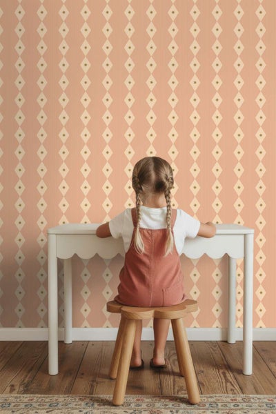 Kindersitzgruppe mit weissem Tisch und Holzhocker vor einer Vliestapete mit Rautenmuster und kleinen Sternen im Kinderzimmer.