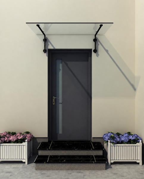 Modernes Vordach aus Klarglas mit schwarzen Halterungen über einer dunklen Haustür, flankiert von Blumenkästen auf dunklen Marmorstufen.