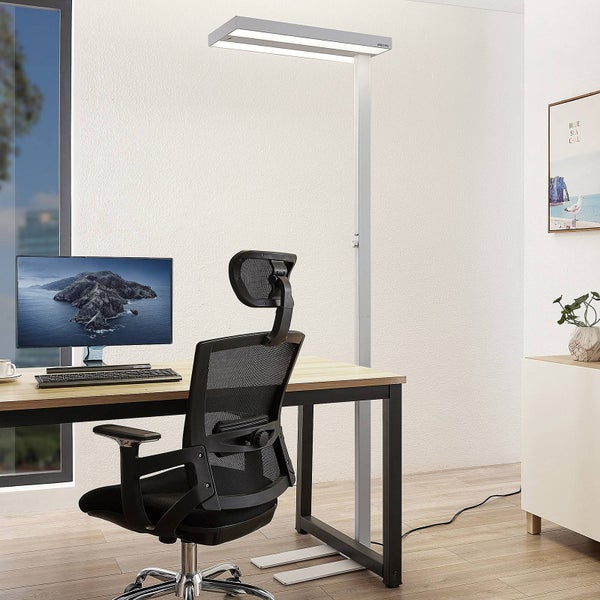 Moderne LED-Stehleuchte für das Büro an einem hellen Arbeitsplatz mit Holzschreibtisch, ergonomischem Bürostuhl und Monitor.