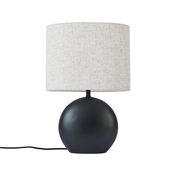 Tischleuchte mit schwarzem Kugelfuß und zylindrischem Stoffschirm in Creme